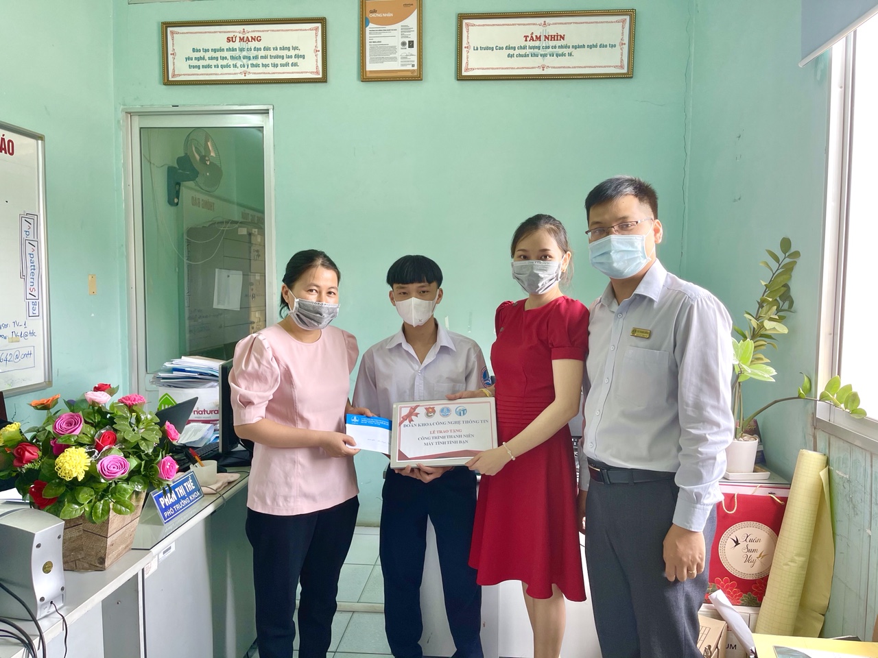 Cô Phan Thị Thể, Anh Vũ Trung Đông và cô Bùi Thị Phương Thảo trao tặng laptop cho em Huỳnh Thanh Sơn